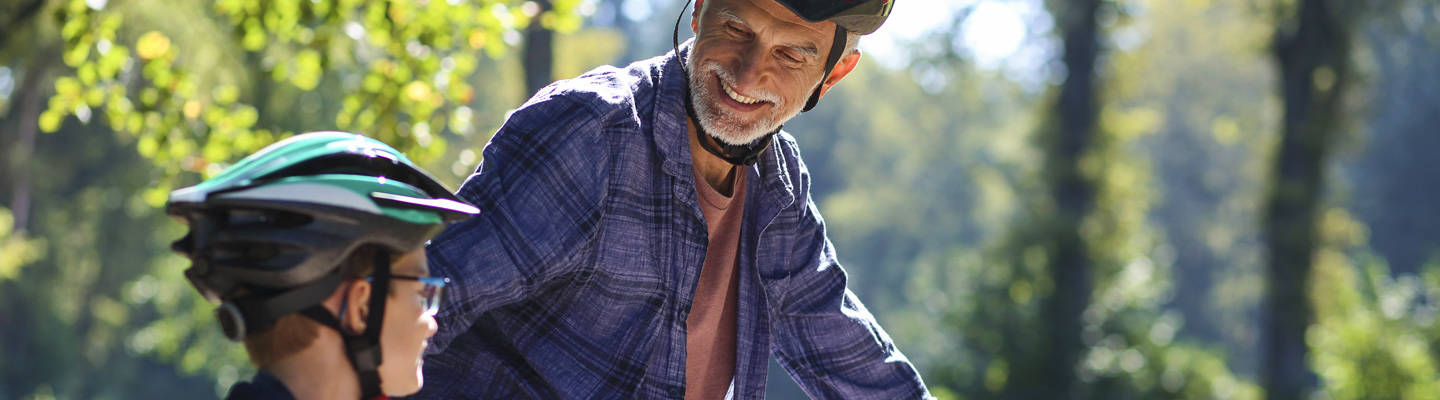 Abuelo con nieto en bicicleta al aire libre