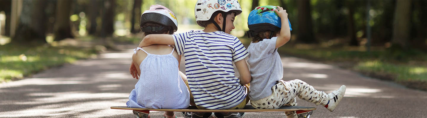 brother and two sisters sitting on skateboard