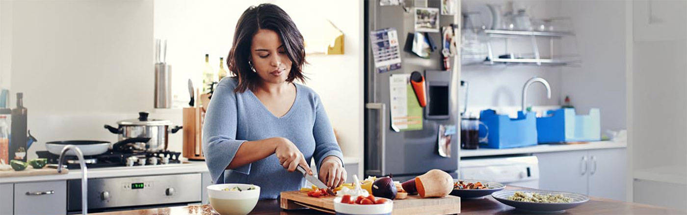 A woman in a kitchen preparing a meal.